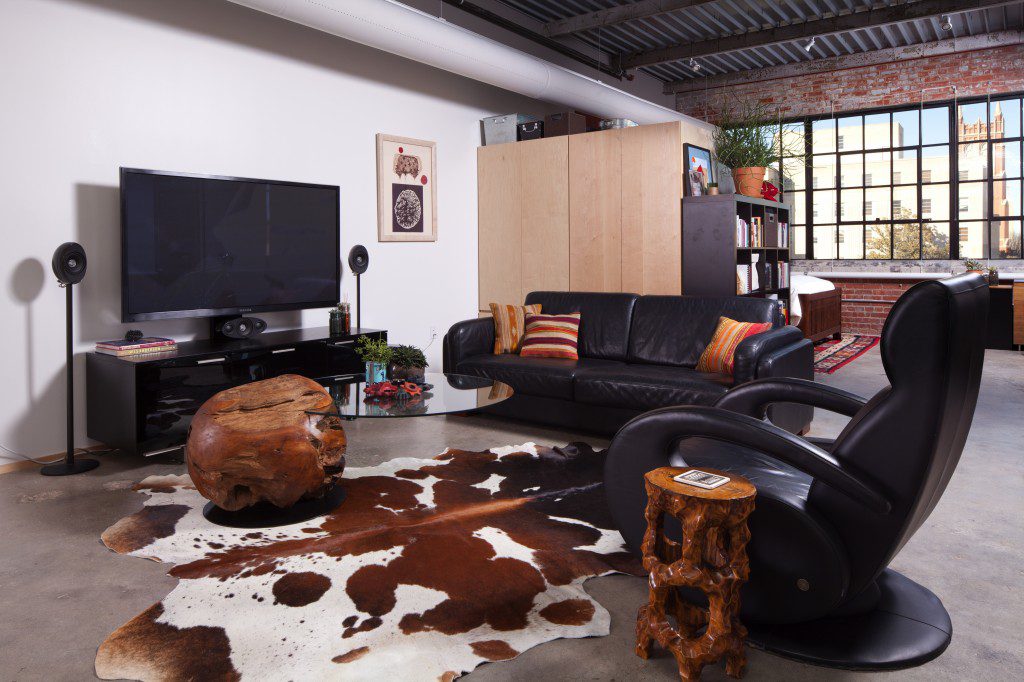 The cozy living room/entertaining area is anchored with an unusual glass coffee table that grooves into a large ornamental teak ball. Photo by David Cobb.