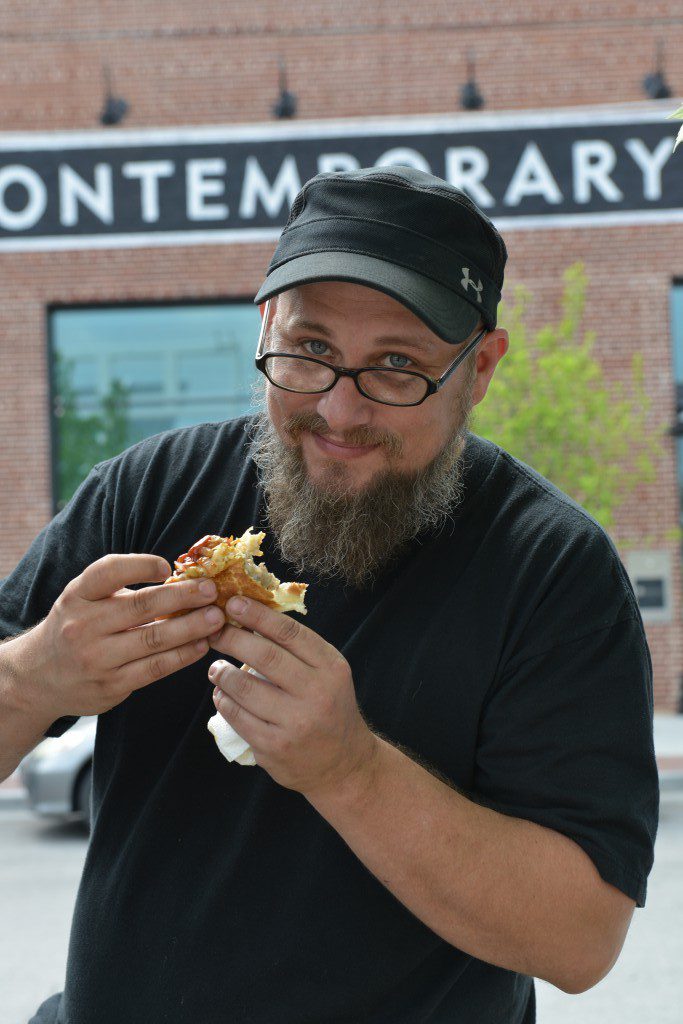 Greg Shocklee enjoys a sausage at lunchtime from The Wurst. Photo by Natalie Green.