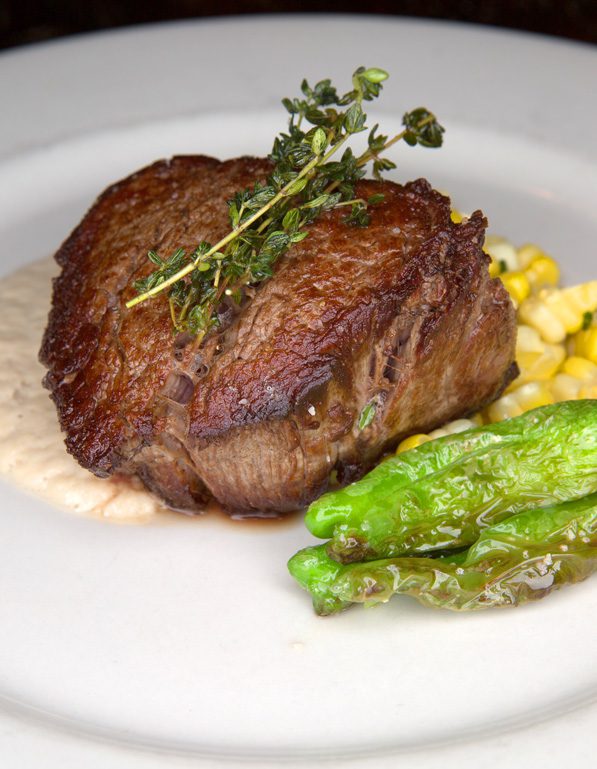 The seared-to-perfection roast beef filet served at Lucky’s Restaurant with shallot  bacon puree, sweet Bixby corn and homegrown shishito peppers. Photo by Brandon Scott.