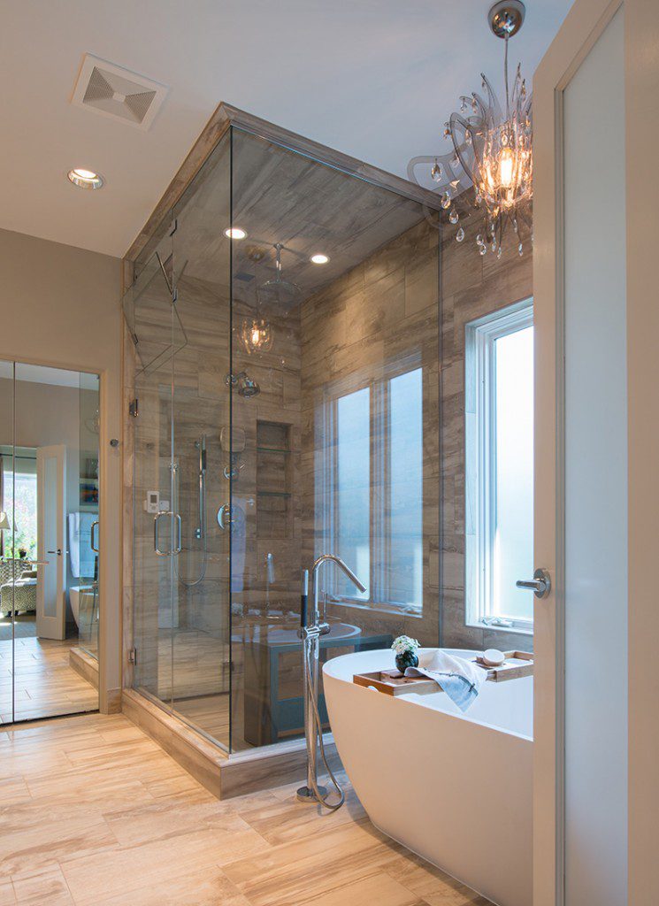 The floor-to-ceiling glass steam shower makes a dramatic statement in this renovated master bath.