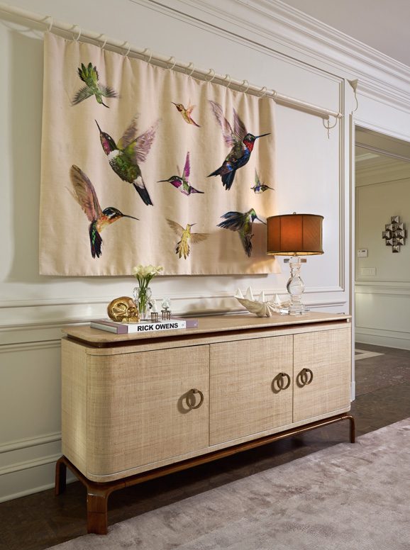 A hummingbird tapestry from the Alexander McQueen collection for The Rug Company hides a recessed flat screen television. Photo by David Cobb 