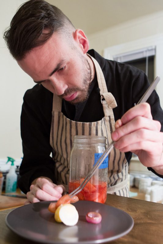 Chef Colin Stringer plates pickled radish for a course at nani. Photo by Brent Fuchs.
