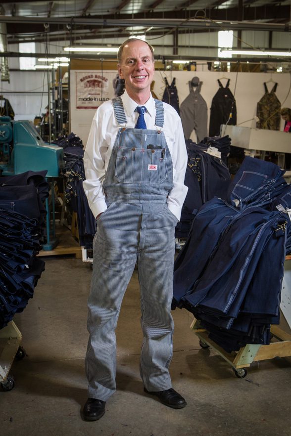 Round House CEO Jim Antosh displays the company’s iconic overalls. Photo by Brent Fuchs.