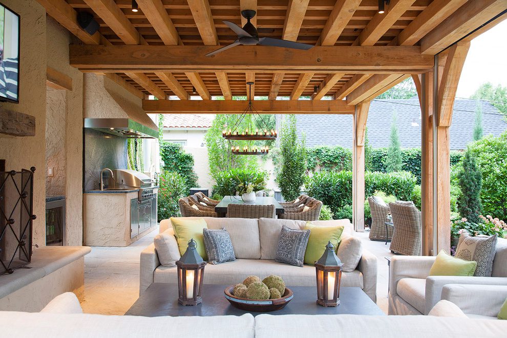 The outdoor dining table seats eight, making this outdoor living space ideal for entertaining. Right: A stone fireplace anchors this sleek outdoor living area and provides warmth during chilly months. Photo by Jenifer Jordan. 