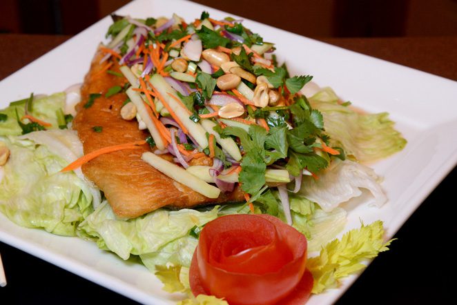 The Pla Song Kraung boasts a crispy fried whole trout filled and topped with shredded green apple, red onion, carrots, lettuce and peanuts. Photo by Natalie Green. 