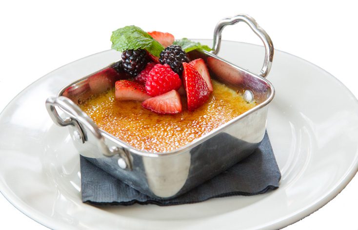 The creme brulee is topped with fresh berries.