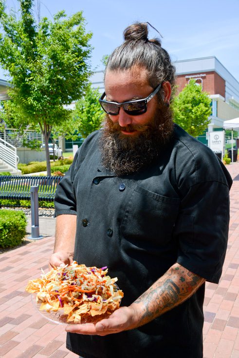 Owner Josh Lynch holding one of his nacho creations. Photos by Natalie Green.