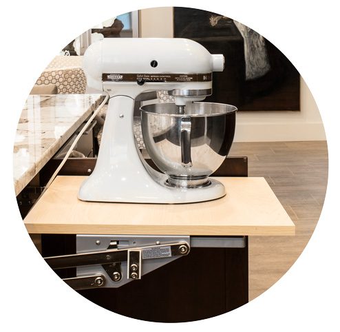 The homeowner requested that the kitchen design offer ways to hide smaller countertop appliances. To accommodate this, Thorp installed cabinets and pop-up shelves beneath the counter and island to house these appliances, such as an espresso machine and a stand mixer.