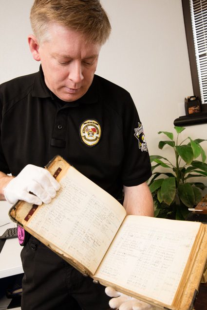 Oklahoma County Sheriff’s Deputy Bradley Wynn displays an artifact at the Oklahoma County Jail. Wynn is working to preserve the artifacts through digital technology.  Photo by Brent Fuchs.