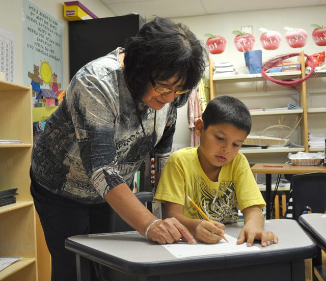 Cherokee Immersion Charter School teacher Meda Nix working with a student. Photo courtesy Cherokee Nation