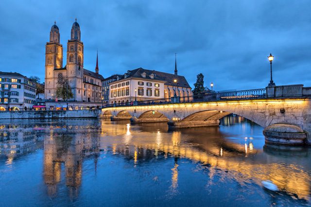 Grossmunster church reflects in the river.