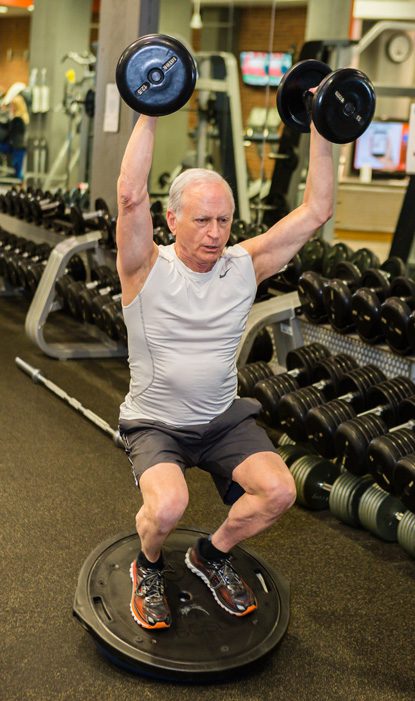 Ronny Altman exercises large and micro muscles with dumbbells atop a bosu ball. Photo by Chris Humphrey Photographer.