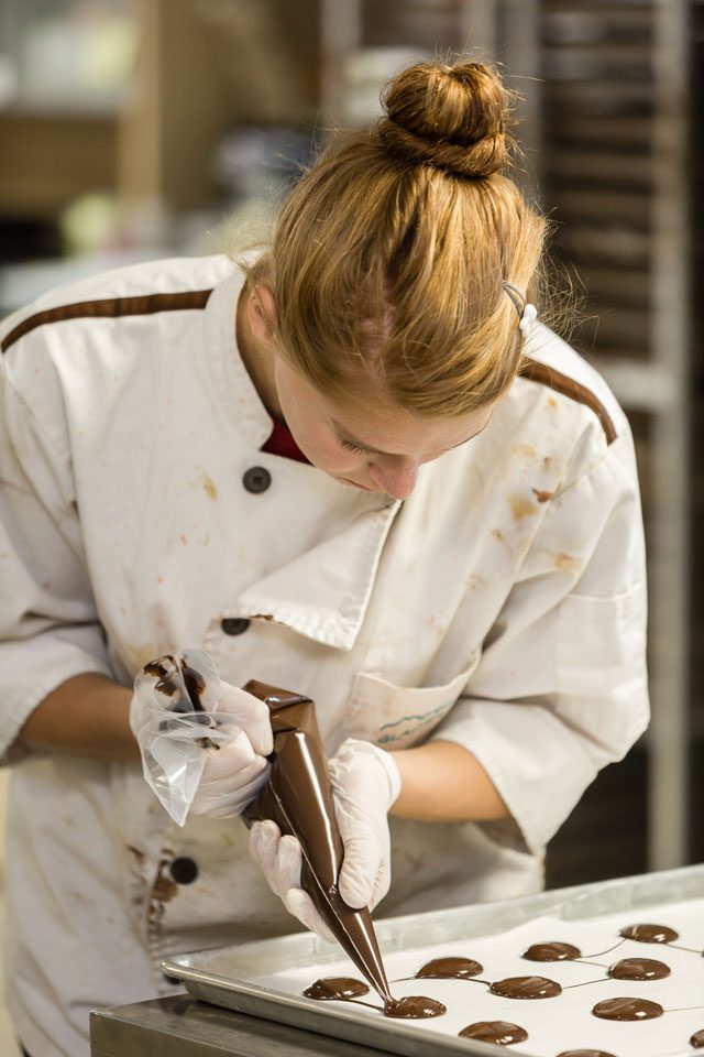 Erin Groff works on creating chocolate in the Glacier factory. Photo by Chris Humphrey Photographer.