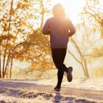 Young man running during autumn, winter morning