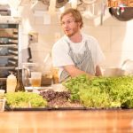 An open window into the kitchen allows for people to see the food beng made.