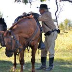 A Civil War reenactor takes a break alongside his horse.