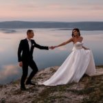 Sensual wedding couple groom and bride in a long white dress sta